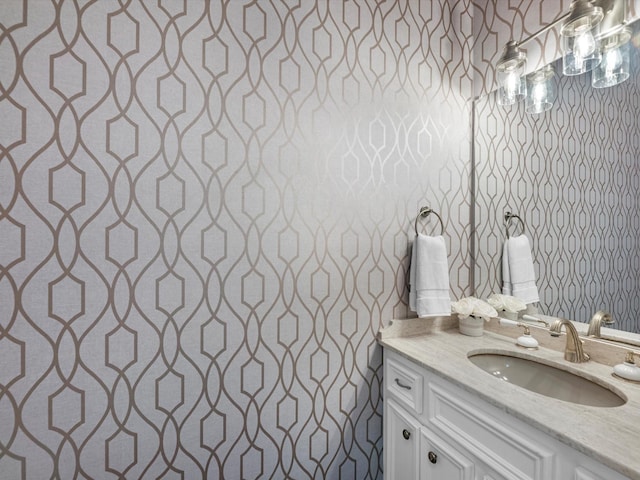 bathroom featuring wallpapered walls and vanity