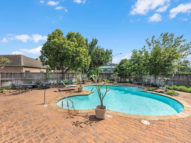 pool featuring a fenced backyard and a patio area