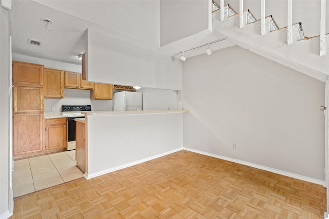 kitchen with white appliances, light countertops, baseboards, visible vents, and a peninsula