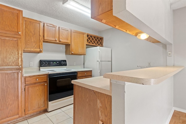 5322 Medical Dr Unit E203, San Antonio, TX 78240 - kitchen featuring electric range, freestanding refrigerator, a peninsula, light countertops, and a textured ceiling
