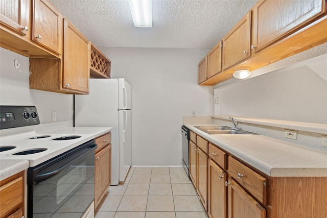 kitchen featuring a sink, light tile patterned floors, electric range oven, dishwashing machine, and a textured ceiling