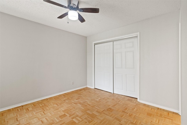 unfurnished bedroom featuring a textured ceiling, ceiling fan, a closet, and baseboards