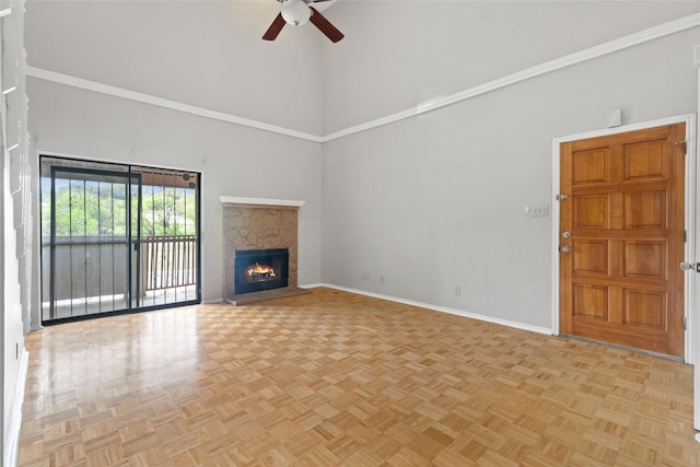 unfurnished living room with a fireplace, a high ceiling, ceiling fan, and baseboards