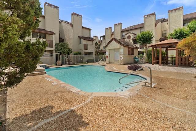 pool with fence, a gazebo, a patio, and a residential view