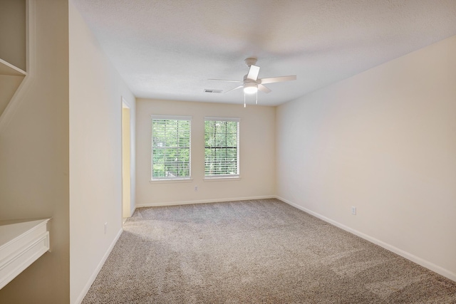 empty room featuring baseboards, visible vents, a ceiling fan, and carpet flooring