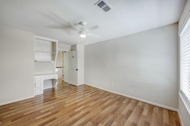 unfurnished bedroom with light wood finished floors, visible vents, and baseboards