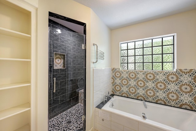 bathroom featuring a garden tub and a shower stall