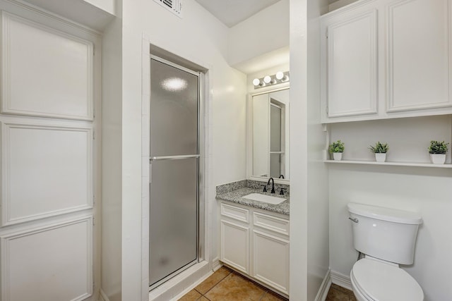 full bathroom featuring a shower stall, vanity, toilet, visible vents, and tile patterned flooring