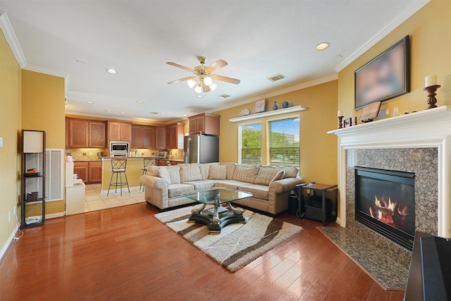 6107 S Arrowana Ln, Houston, TX 77036 - living area featuring ceiling fan, ornamental molding, light wood-style floors, a fireplace, and recessed lighting
