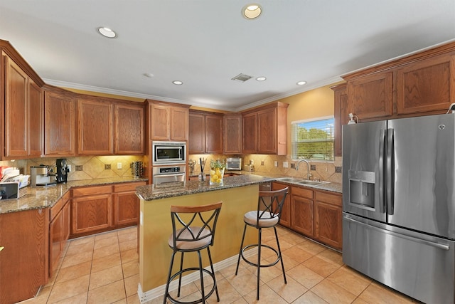 6107 S Arrowana Ln, Houston, TX 77036 - kitchen featuring stainless steel appliances, a sink, ornamental molding, light tile patterned flooring, and dark stone countertops