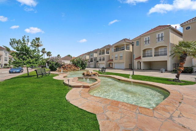 view of community featuring a yard, an attached garage, and a residential view