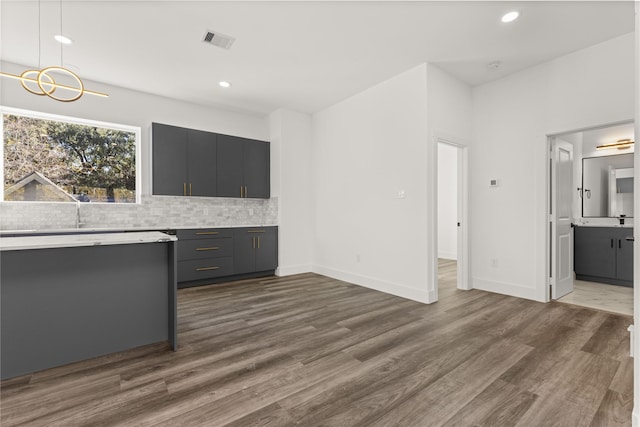 2707 Dennis St, Houston, TX 77004 - kitchen featuring recessed lighting, visible vents, backsplash, light countertops, and dark wood finished floors