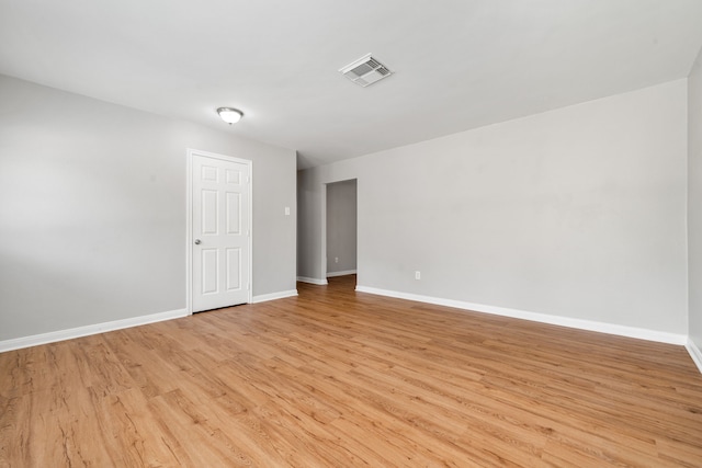 empty room featuring visible vents, baseboards, and light wood-style floors
