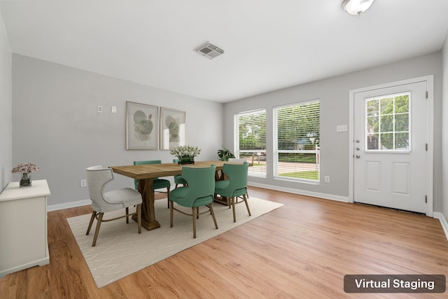 dining room featuring light wood-type flooring, visible vents, a wealth of natural light, and baseboards