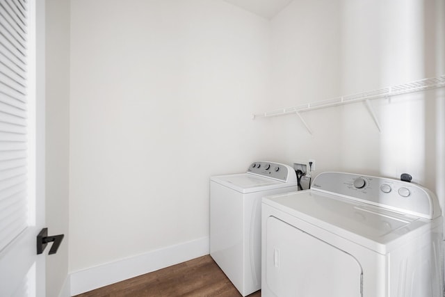 laundry area featuring baseboards, dark wood-style flooring, washing machine and clothes dryer, and laundry area