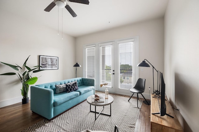 living area featuring wood finished floors, ceiling fan, and baseboards