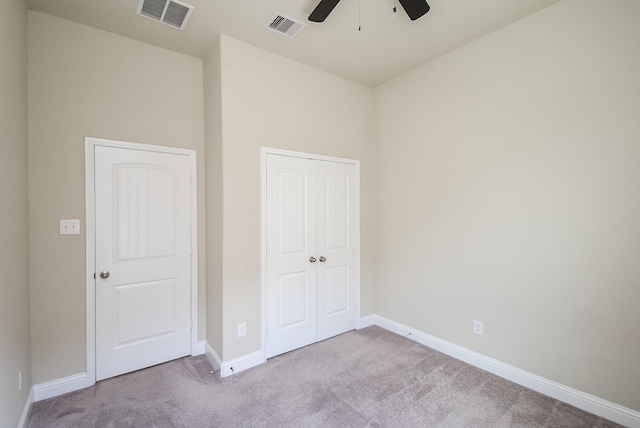 unfurnished bedroom with baseboards, carpet, a closet, and visible vents
