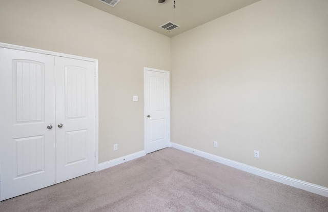 unfurnished bedroom with visible vents, baseboards, carpet floors, and a closet