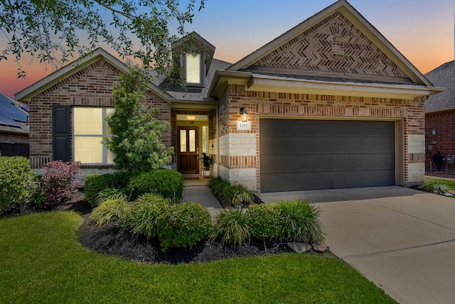 view of front of home with brick siding, a garage, a front yard, and concrete driveway