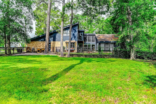 back of house featuring fence and a yard