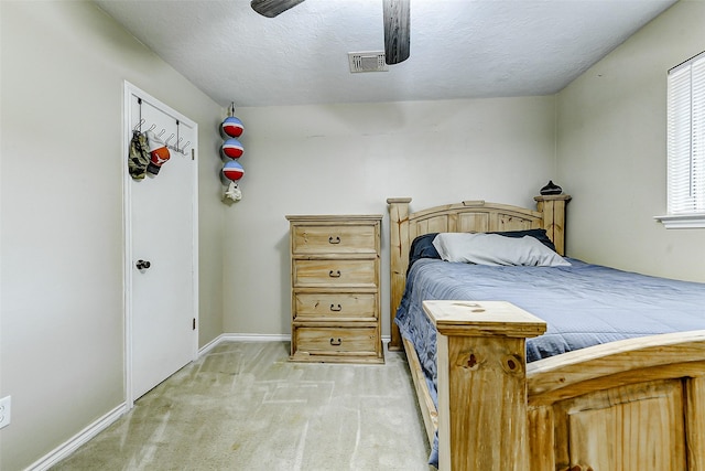 bedroom with visible vents, baseboards, a ceiling fan, and light carpet