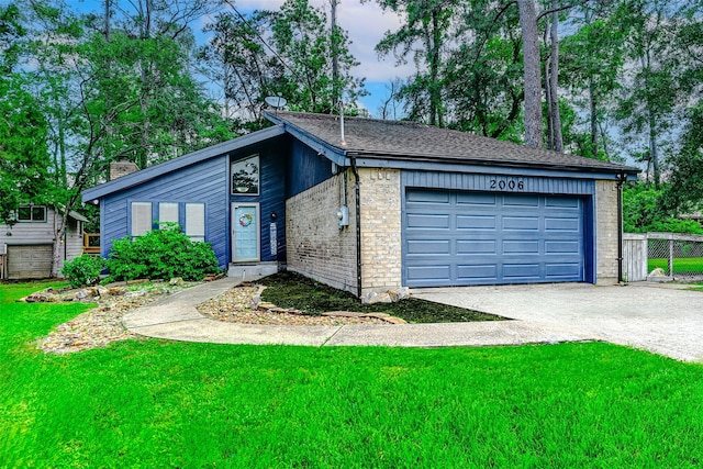 mid-century inspired home featuring a front lawn, a garage, brick siding, driveway, and a chimney