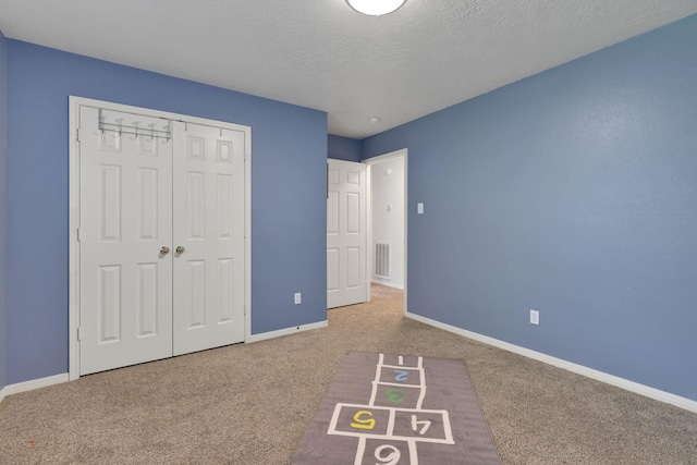 3739 Apple Hollow Ln, Humble, TX 77396 - unfurnished bedroom featuring carpet floors, baseboards, a closet, and a textured ceiling