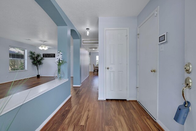 3739 Apple Hollow Ln, Humble, TX 77396 - corridor with arched walkways, wood finished floors, healthy amount of natural light, baseboards, and a textured ceiling