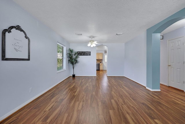 3739 Apple Hollow Ln, Humble, TX 77396 - unfurnished room with arched walkways, wood finished floors, a ceiling fan, baseboards, and a textured ceiling