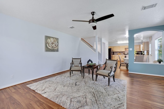 3739 Apple Hollow Ln, Humble, TX 77396 - sitting room featuring arched walkways, a ceiling fan, wood finished floors, and baseboards