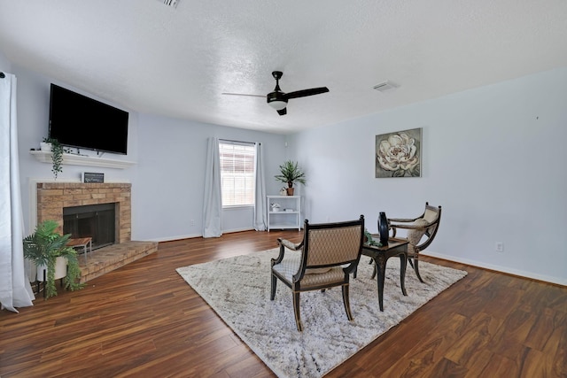 3739 Apple Hollow Ln, Humble, TX 77396 - dining area with a ceiling fan, baseboards, a fireplace, a textured ceiling, and dark wood finished floors