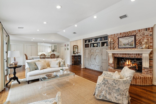 living room featuring visible vents, wood finished floors, a fireplace, recessed lighting, and vaulted ceiling