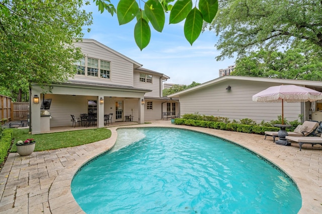 outdoor pool with fence, a patio, and french doors