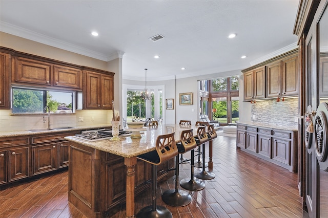 90 Greenview St, Montgomery, TX 77356 - kitchen with a sink, stainless steel gas cooktop, dark wood-type flooring, plenty of natural light, and ornamental molding