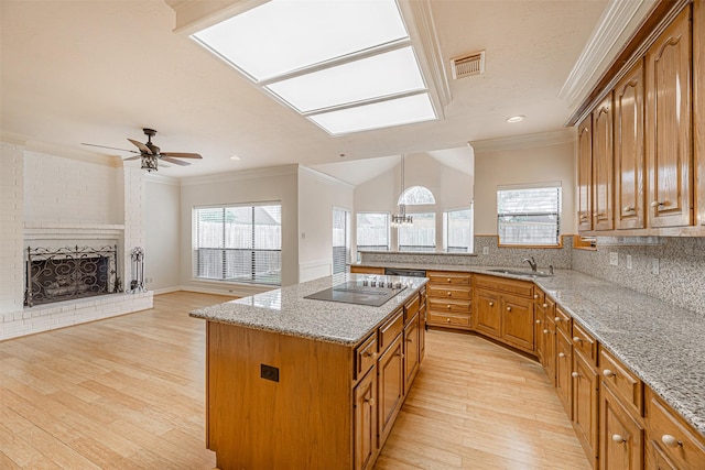 kitchen with a sink, visible vents, ornamental molding, and black electric cooktop