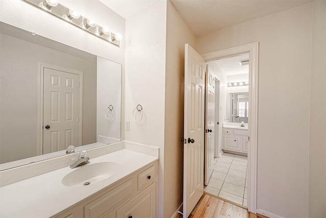 bathroom with wood finished floors and vanity