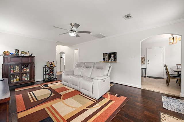 living room featuring a ceiling fan, visible vents, crown molding, arched walkways, and hardwood / wood-style flooring