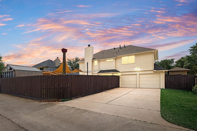 exterior space featuring concrete driveway, an attached garage, and fence