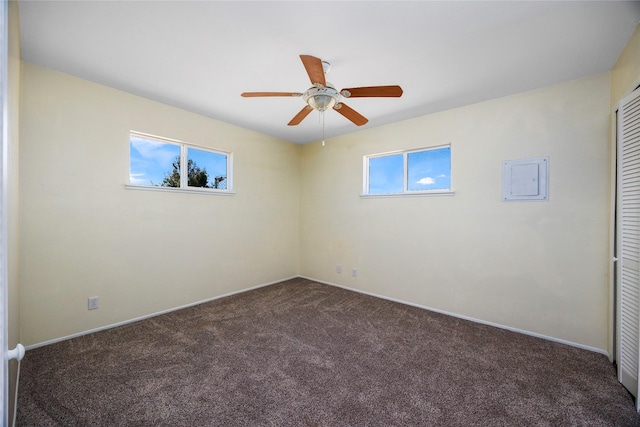 unfurnished room with a wealth of natural light, ceiling fan, carpet flooring, and baseboards