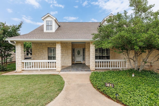 440 Saint Andrews St, Meadowlakes, TX 78654 - view of front facade with a porch, roof with shingles, stone siding, and a front yard