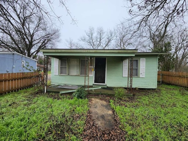 bungalow-style home with fence and covered porch