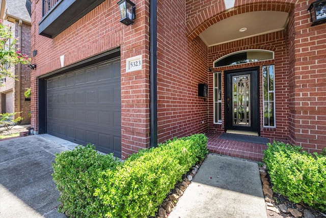 entrance to property with concrete driveway, brick siding, and a garage