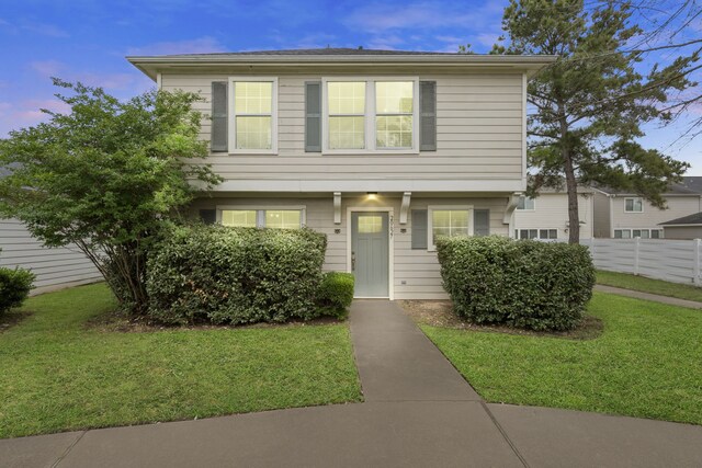 view of front of home with fence and a front lawn