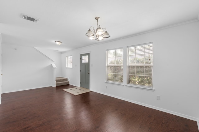 entrance foyer featuring an inviting chandelier, stairway, baseboards, visible vents, and crown molding