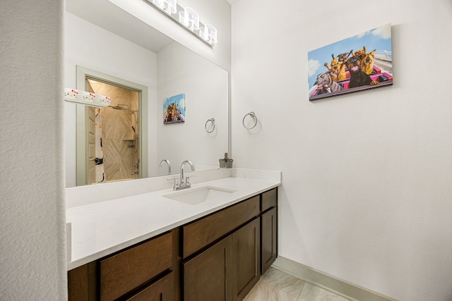 full bath featuring vanity, baseboards, and marble finish floor