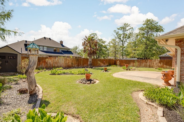 view of yard with an outbuilding, a shed, a patio, and a fenced backyard