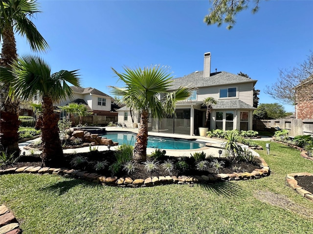 view of swimming pool with a pool with connected hot tub, a fenced backyard, a yard, and a sunroom