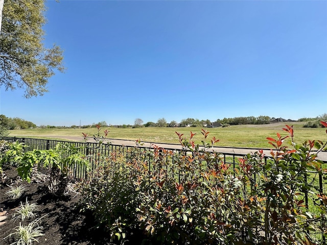 view of yard featuring fence and a rural view