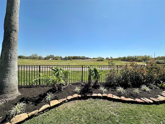 view of yard with fence and a rural view