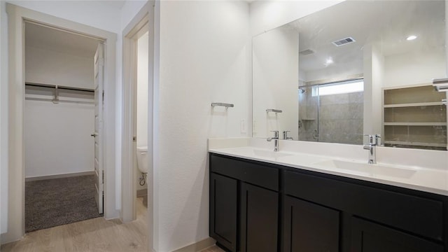 30106 Reagans Ranch Dr, Katy, TX 77494 - bathroom with a stall shower, a sink, wood finished floors, and visible vents